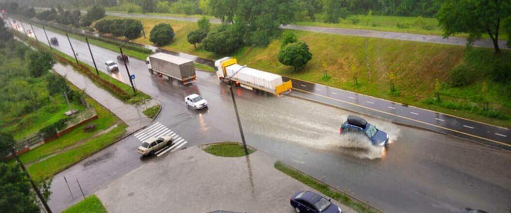 Semis and cars traveling on a highway after heavy showers