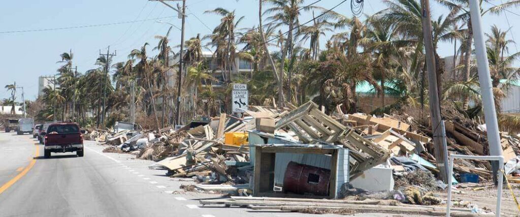 Hurricane debris pilled up on the side of a highway.